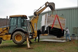 Generator being placed by piece of heavy equipment